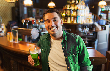 Image showing man drinking green beer at bar or pub