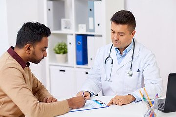 Image showing doctor and patient signing document at clinic