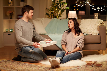 Image showing happy couple with food on tray at home