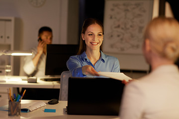 Image showing businesswomen with papers working late at office