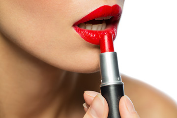 Image showing close up of woman applying red lipstick to lips