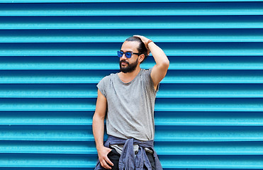 Image showing man in sunglasses posing over ribbed blue wall