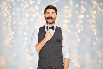 Image showing happy young man with fake mustache at party
