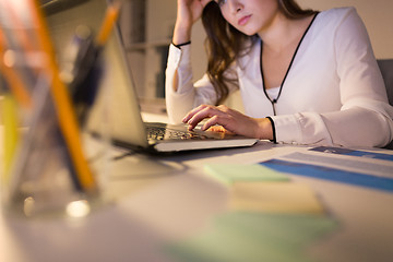 Image showing businesswoman with laptop working at night office