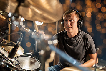 Image showing musician playing drum kit at concert over lights