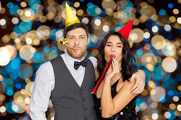 Image showing happy couple with party blowers having fun