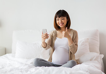 Image showing pregnant woman taking selfie by smartphone at home