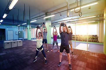 Image showing group of people with kettlebells exercising in gym