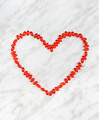 Image showing Red pills heart on marble background