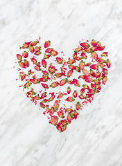 Image showing Dried rose flowers heart on marble background