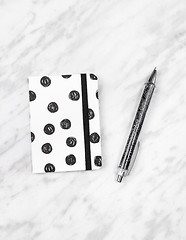 Image showing Black and white diary and pen on marble background