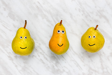 Image showing Funny smiling pears on marble background