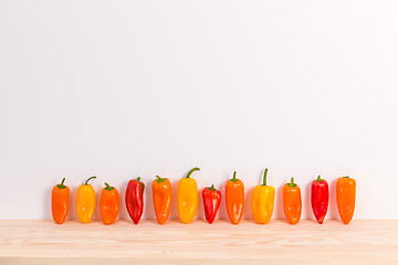 Image showing Colorful sweet peppers on wooden surface