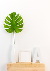 Image showing Elegant home decor with picture frame and tropical leaf