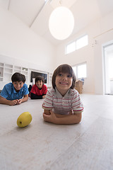 Image showing boys having fun with an apple on the floor