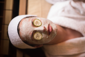 Image showing woman is getting facial clay mask at spa