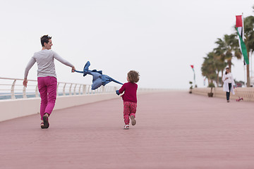 Image showing mother and cute little girl on the promenade by the sea