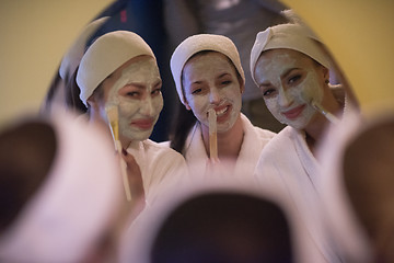 Image showing women putting face masks in the bathroom