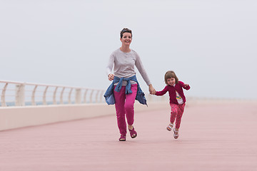 Image showing mother and cute little girl on the promenade by the sea