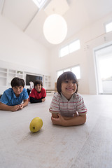 Image showing boys having fun with an apple on the floor