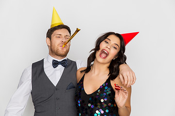 Image showing happy couple with party blowers having fun