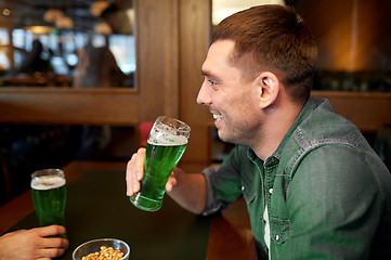 Image showing man drinking green beer at bar or pub