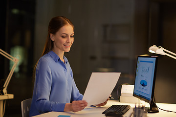 Image showing businesswoman with papers working at night office