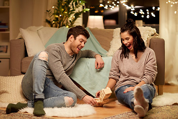 Image showing happy couple playing block-stacking game at home