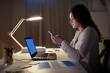 Image showing businesswoman with smartphone and laptop at office