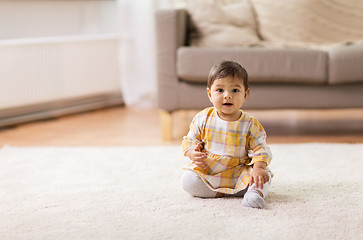 Image showing happy smiling baby girl sitting on floor home