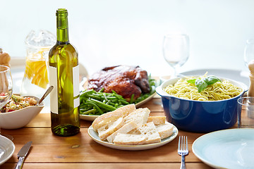 Image showing bottle of wine and food on served wooden table