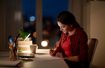 Image showing student girl with laptop and notebook at home