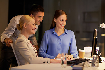 Image showing business team with computer working late at office