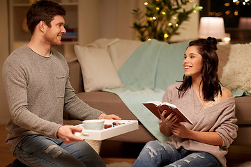 Image showing happy couple with book and food at home