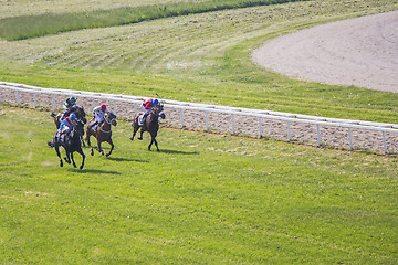 Image showing Galloping race horses and jockeys in racing competition