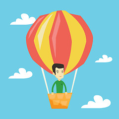 Image showing Young man flying in hot air balloon.