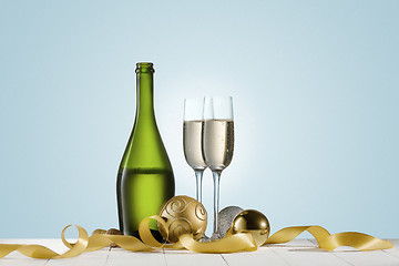 Image showing Glasses with champagne and bottle over sparkling holiday background