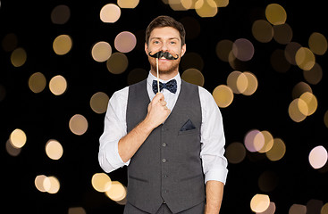 Image showing happy young man with fake mustache at party