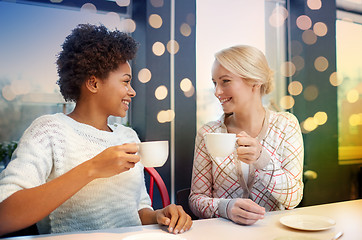 Image showing happy young women drinking tea or coffee at cafe