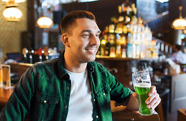 Image showing man drinking green beer at bar or pub