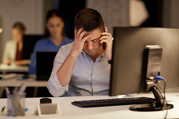 Image showing businessman calling on sartphone at night office