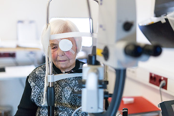 Image showing Senior woman wearing eye pathc after laser surgery procedure at ophthalmology clinic.