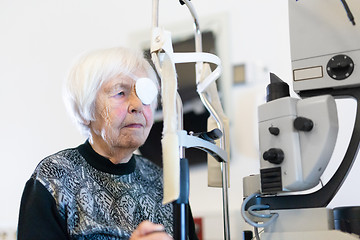 Image showing Senior woman wearing eye pathc after laser surgery procedure at ophthalmology clinic.