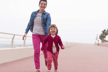 Image showing mother and cute little girl on the promenade by the sea