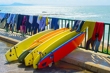 Image showing Surfboards and wetsuits at beach