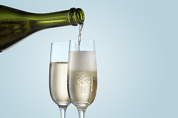 Image showing Glasses with champagne and bottle over sparkling holiday background