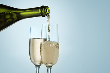 Image showing Glasses with champagne and bottle over sparkling holiday background