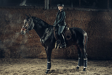 Image showing Image of happy female sitting on purebred horse