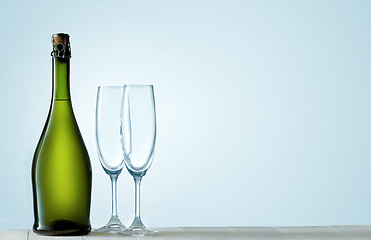 Image showing Glasses with champagne and bottle over sparkling holiday background