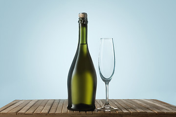 Image showing Glasses with champagne and bottle over sparkling holiday background